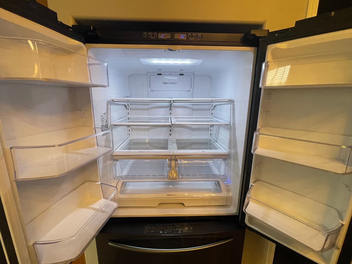 Empty refrigerator with wiped-clean glass shelves after a DSM Cleaning Solutions move-out clean